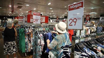 Varios clientes eligen entre los productos rebajados de un centro comercial en Madrid.