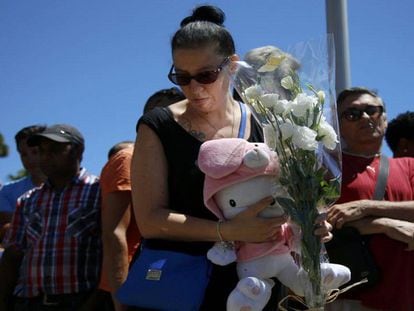 Una dona porta flors i un peluix a l'escenari de la matança aquest divendres.