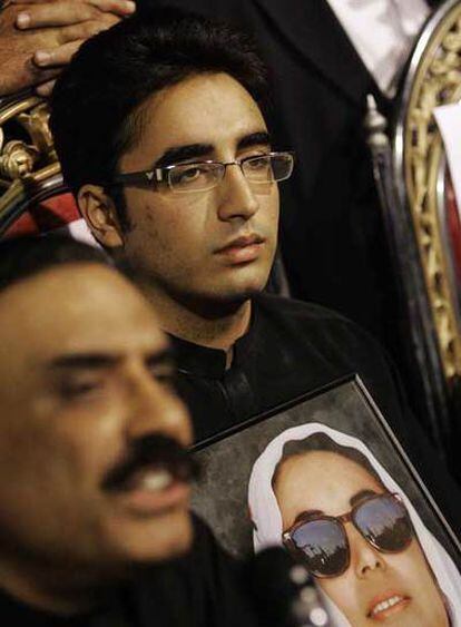 Bilawal sujeta la foto de su madre mientras sigue la intervención de su padre (en primer plano), ayer en Naudero.
