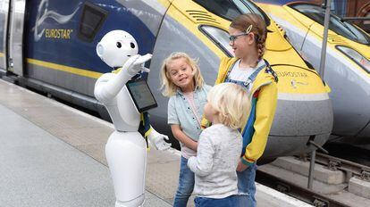El robot Pepper interactúa con tres niños en una estación de tren en Londres.