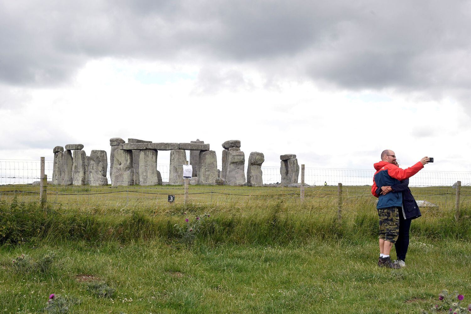 Una pareja de turistas junto al conjunto de Stonehenge, uno de los puntos turísticos más visitados de Reino Unido.