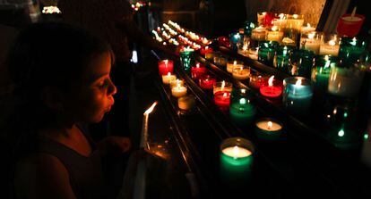 Velas encendidas en el interior de la iglesia de St. Pierre, erigida entre los siglos XI y XV. Situada en la Grand Rue, calle principal que sube a la abadía, en su interior se encuentra la capilla de San Miguel, que guarda una venerada imagen del santo revestida de plata.