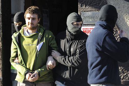 Varios policías llevan esposado a Imanol Beristain, uno de los detenidos ayer, en la localidad bilbaína de Romo.