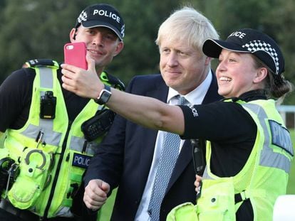 El primer ministro británico, Boris Johnson, se fotografía con dos policías en un acto el pasado viernes.
