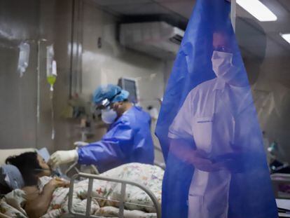 Dos trabajadores del Hospital de Clínicas de San Lorenzo (Paraguay) trabajan con una enferma de covid-19.