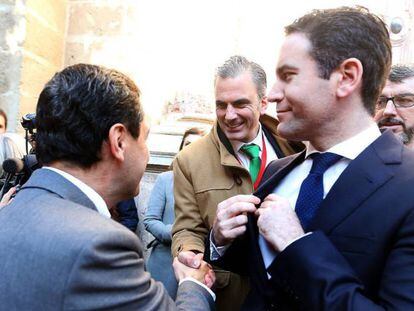 El líder del PP andaluz, Juanma Moreno saluda al secretario general de VOX, Javier Ortega, ante Teodoro García Egea. 