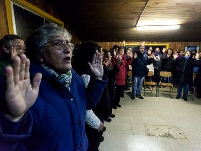 Un grupo de feligreses rezan en un centro comunitario en Osorno.