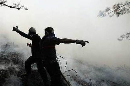 Dos bomberos luchan contra el fuego en el municipio de Pobra do Caramiñal.