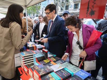 El primer secretario del PSC, Sañvador Illa, junto a la portavoz parlamentaria Alícia Romero, conversa con una librera en una parada de Sant Jordi. / PSC
