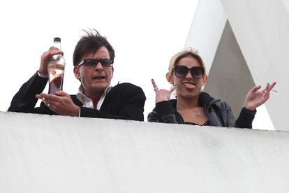Charlie Sheen saluda a la prensa desde una azotea, cigarro y botella de licor en mano, en 2011.