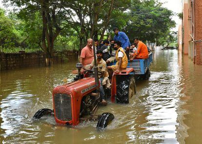 Los residentes son evacuados a lugares más seguros en un tractor después de que las fuertes lluvias causaron inundaciones en una zona residencial de Bangalore, India.