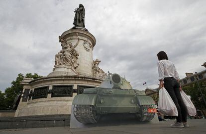 Una miembro del Movimiento Mundial de Derechos Humanos posa frente a un tanque, recreando la icónica fotografía del 'hombre del tanque', en la Plaza de la República de París.