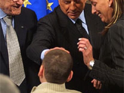Silvio Berlusconi saluda a un niño en el palacio Chigi de Roma.