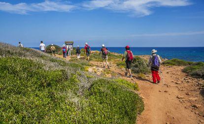 Senderistas en el Camí de Cavalls, cerca de cala Pilar, en la costa norte de Menorca.