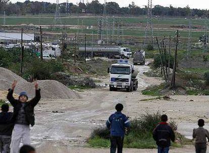 Niños palestinos de la franja de Gaza observan el ingreso de camiones con combustible por el paso de Nahal Oz.