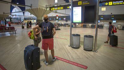 Pasajeros miran las pantallas informativas en la terminal de salidas del aeropuerto de San Pablo, Sevilla, el 19 de agosto.