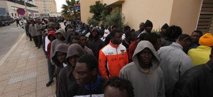 Inmigrantes llegados a Melilla el martes hacen cola para que les tomen la filiación en la comisaría de la ciudad.