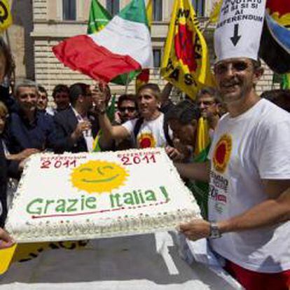 Angelo Bonelli, presidente del partido italiano de los Verdes, recibe una tarta de regalo mientras celebra los resultados del referendo sobre la energía nuclear