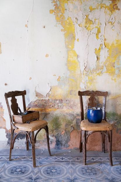 Salita de estar en la casa La Lázara, con sillas y otros objetos encontrados allí. Las pinturas parecen de finales del XIX o principios del XX.