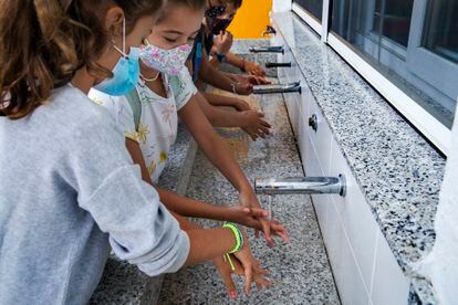 Un grupo de alumnos se lava las manos en un colegio de Valencia.







