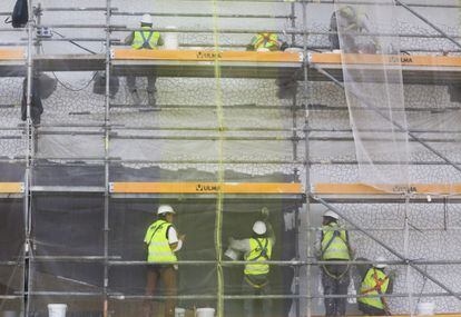 Obreros colocando los 20.000 metros cuadrados del trencadis que reviste la fachada del centro operístico y que comenzó a caerse a finales de 2013.