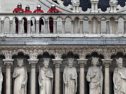 Bomberos trabajando sobre la galería de reyes de la catedral de Notre Dame. En vídeo, la historia tras los muros de la catedral.