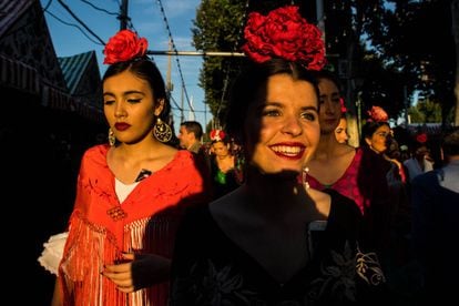 SEVILLE, SPAIN - MAY 01:  Women wearing traditional Sevillana dresses enjoy the atmosphere at the Feria de Abril (April's Fair) on May 1, 2017 in Seville, Spain. The Feria de Abril, which has a story dating back to 1857, takes place a fortnight after Easter each year. The origin of the fair was a cattle market but the event quickly turned its goal from commerce to having fun. More than one million local and international participants are expected to attend to Feria de Abril.  (Photo by David Ramos/Getty Images)