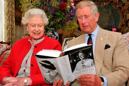 Madre e hijo hojean el primer ejemplar de un libro publicado sobre la Reina Madre.