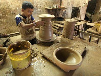 Un joven palestino hace vasijas de arcilla en un taller en Gaza