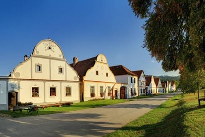 El orgullo de Holašovice, apenas 200 habitantes en mitad de un paisaje armónico, es su sucesión de fachadas de fincas barrocas (en la foto) alrededor de su extensa plaza. Esta pequeña villa ha conservado el mismo número de fincas a lo largo de sus 800 años de historia: 17 caseríos con granjas y establos, una herrería, dos cervecerías y la capilla de san Juan Nepomuceno. Un sistema medieval de edificios y graneros bien conservados, y casas y fachadas reformadas en los siglos XVIII y XIX, en estilo barroco rural o rústico, declarado patrimonio mundial. Hay un taller de cerámica y, en la finca número seis, el viajero puede acercarse a la vida tradicional.