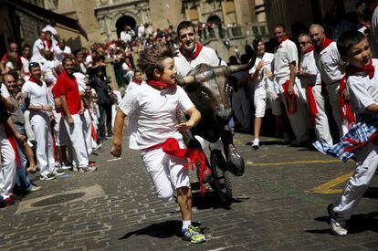 Un ni&ntilde;o corre delante de un toro de juguete en el &#039;encierro txiki&#039; (encierro infantil) de las fiestas de San Ferm&iacute;n en Pamplona. 