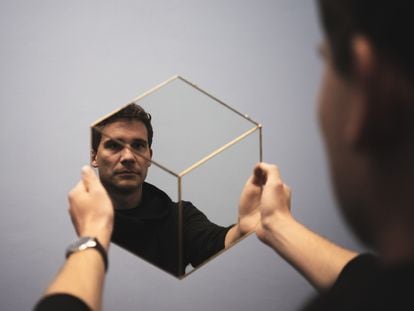 Un hombre mira su reflejo en un espejo.