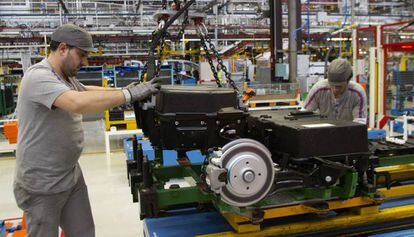 Dos operarios colocan hoy las baterías de la furgoneta eléctrica Citroën Berlingo en la cadena de montaje de la planta de PSA. 