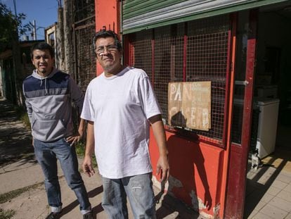 Luis Cáceres (dcha), junto a su hijo Yamil, frente al negocio de comidas familiar en Lomas de Zamora.