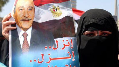 Una partidaria de Omar Suleiman sostiene un poster que lo llama a participar en las elecciones.