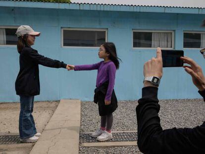 Dos niñas se dan la mano en la réplica de la Zona Desmilitarizada, en Corea del Sur.
