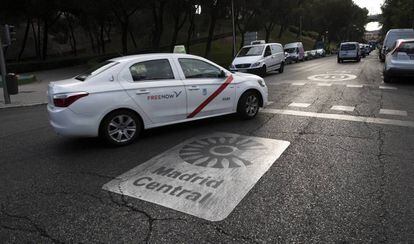 Un taxi pasa por una señal de Madrid Central.