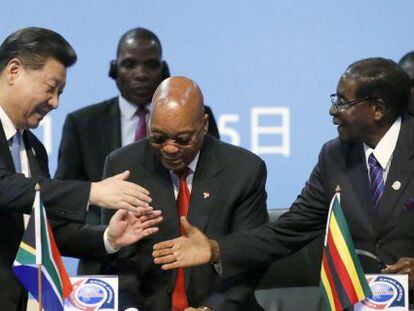 El presidente chino Xi saluda a sus homólogos zimbabuense Robert Mugabe y sudafricano Jacob Zuma en la cumbre de Johanesburgo.
