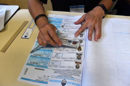 A member of a polling station confirms the identity of a voter, on October 22, in Buenos Aires. 