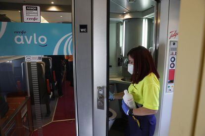 Una trabajadora de la limpieza higieniza uno de los cuartos de baño del tren.