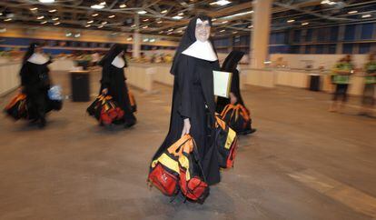 Un grupo de monjas recoge las mochilas que reparten los voluntarios.