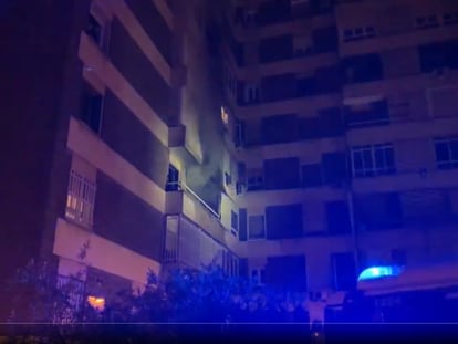 El humo sale por el balcón de la vivienda incendiada, en la avenida de Ferrol.