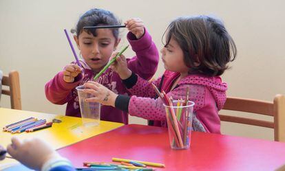 Dos niñas juegan con lápices de colores en una de las aulas.