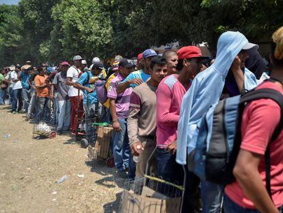 Decenas de migrantes venezolanos hacen cola para recibir comida en un refugio de Villa del Rosario (Venezuela).