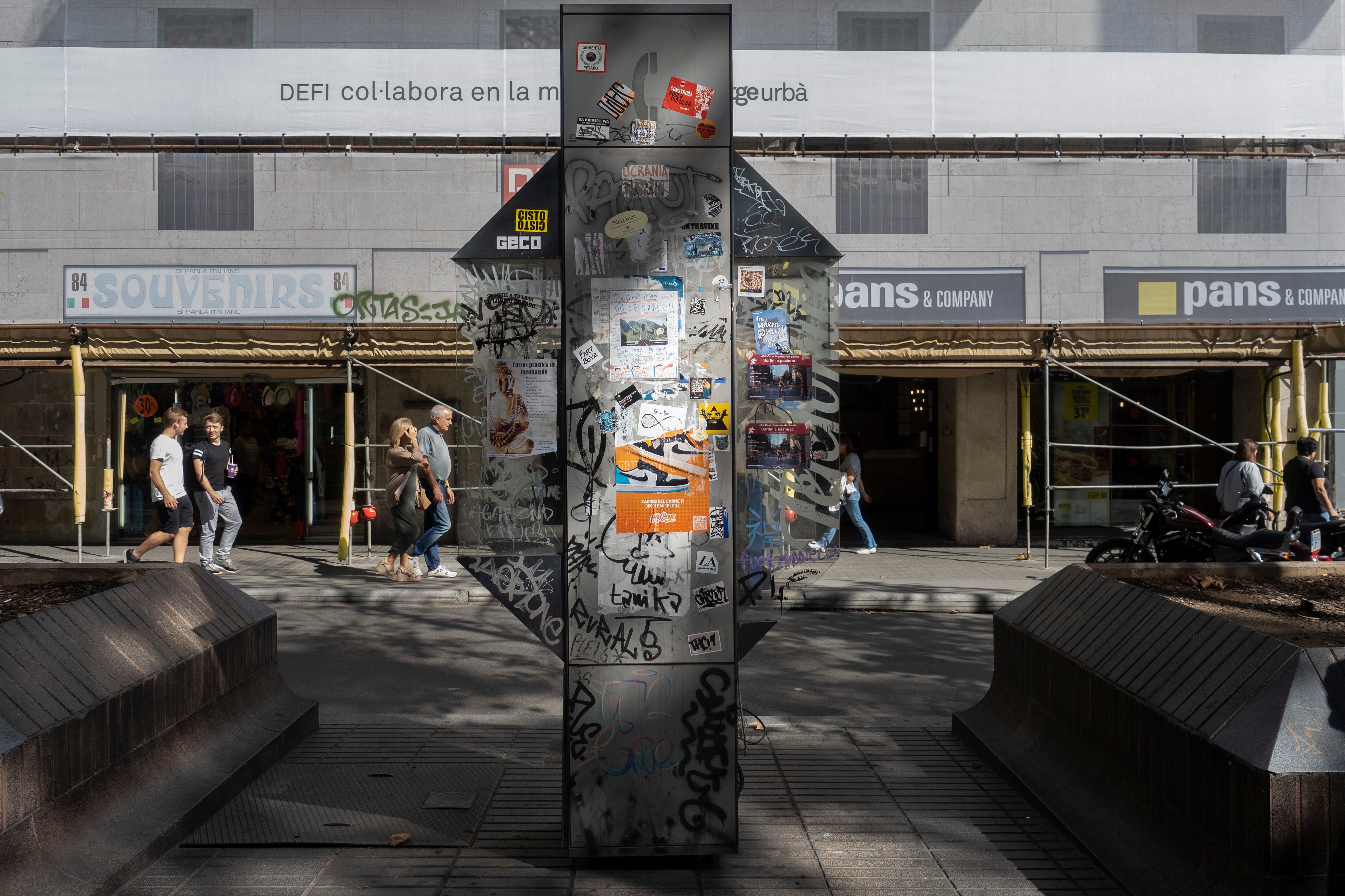Cabina telefónica vandalizada, con pintadas e inutilizada, este miércoles en la Rambla de Barcelona.
