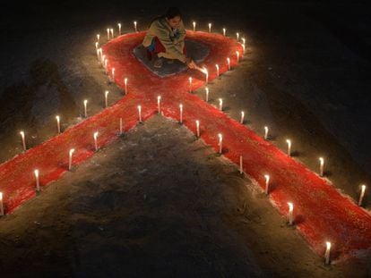 An Indian sex worker lights candles forming the shape of a ribbon as part of an awareness event on the occasion of World AIDS Day in Siliguri on December 1, 2018. - World AIDS Day has been observed today since 1988 to raise awareness of the AIDS pandemic. (Photo by DIPTENDU DUTTA / AFP)