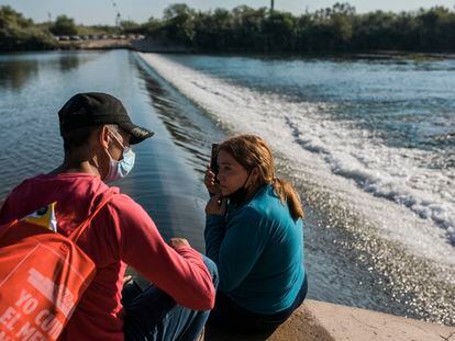 Una pareja inmigrante de Cuba espera intentar cruzar el Río Grande desde Ciudad Acuña, México, hacia Del Río, Texas, el domingo 19 de septiembre de 2021.