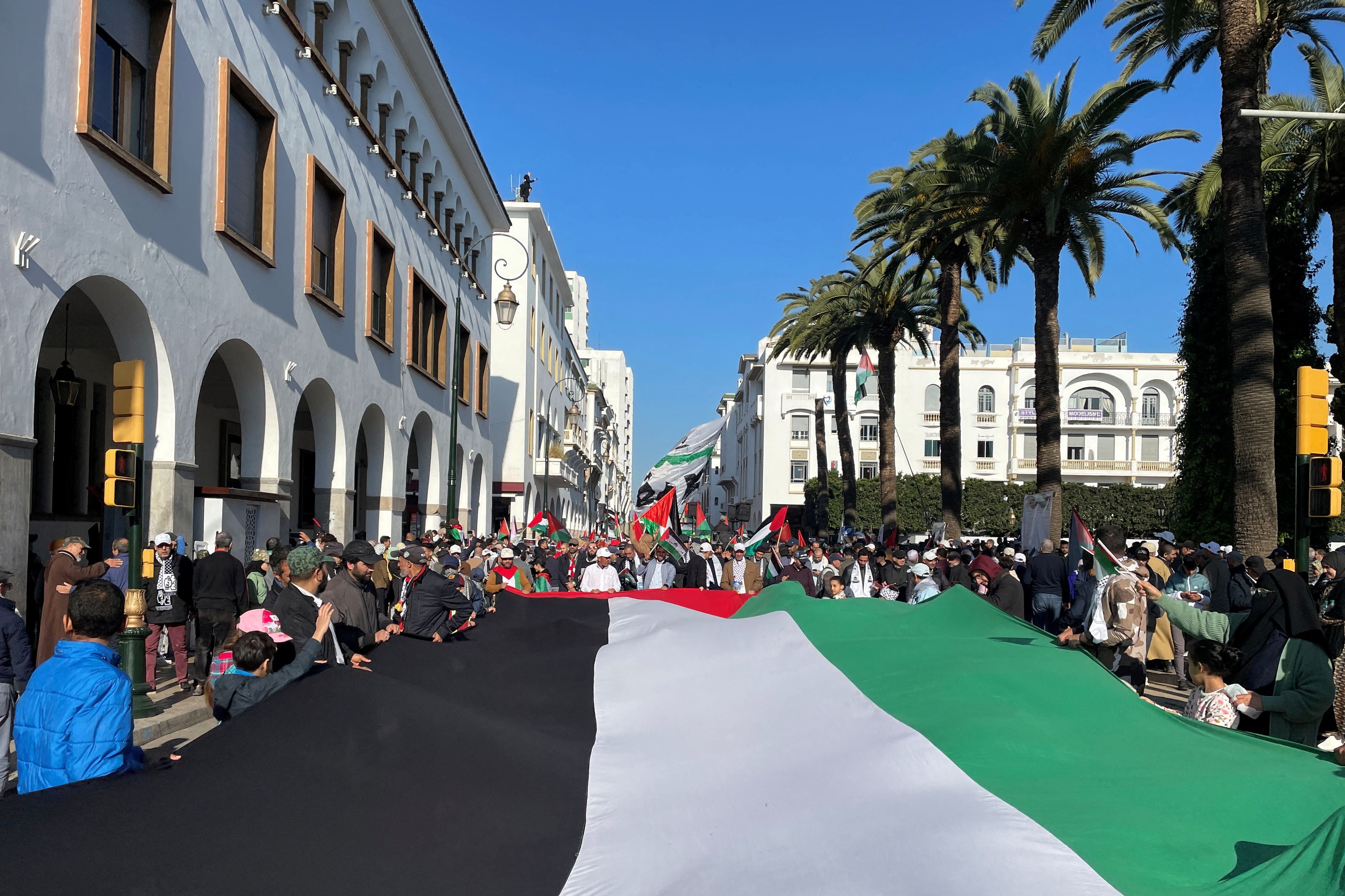 Protesters carry a giant Palestinian flag, calling for an end to Morocco's ties with Israel, amid the ongoing conflict between Israel and Palestinian Islamist group Hamas, in Rabat, Morocco December 24, 2023. REUTERS/Ahmed El Jechtimi NO RESALES. NO ARCHIVES