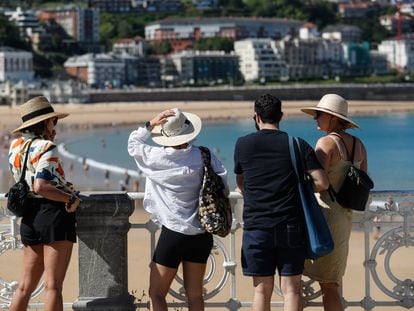 Unos turistas visitan este martes la playa de la Concha de San Sebastián.