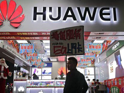 Un hombre pasea junto a una tienda con un logotipo de Huawei en China.